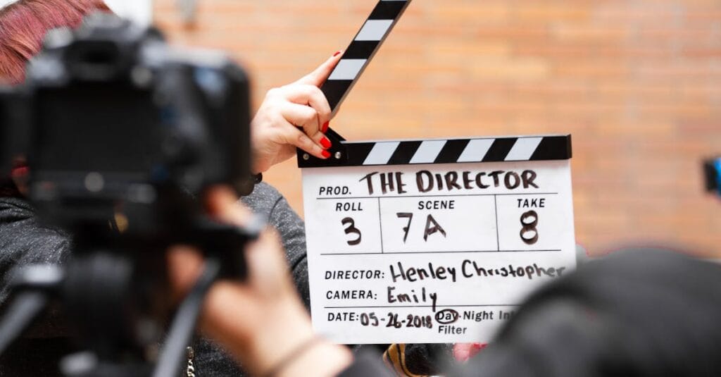 Close-up of film clapperboard in action with camera filming a take on set.
