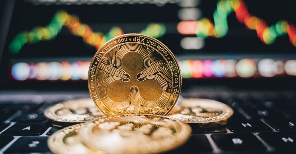 Golden Ripple XRP coins on laptop, symbolizing cryptocurrency trends and online trading.